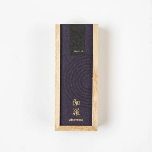 A rectangular wooden box labeled Aloeswood with deep purple and black packaging, photographed from above on a white surface.