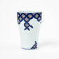 Front view of a Gen-emon porcelain cup with a brocade cloisonné crest design, showcasing a traditional geometric pattern in blue and red, accentuated by the cup's elegant tapered shape, representing Japanese artistry.