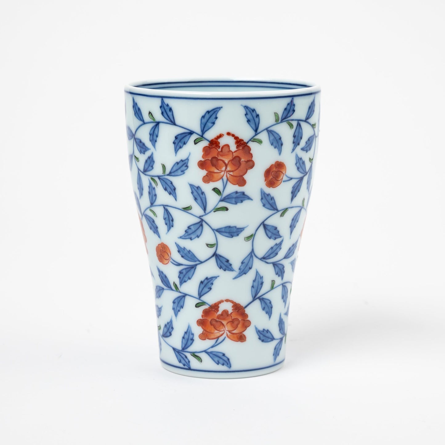 Front view of a Gen-emon porcelain cup adorned with a floral karakusa design, featuring delicate orange flowers intertwined with blue vines, representing traditional Japanese porcelain artistry.