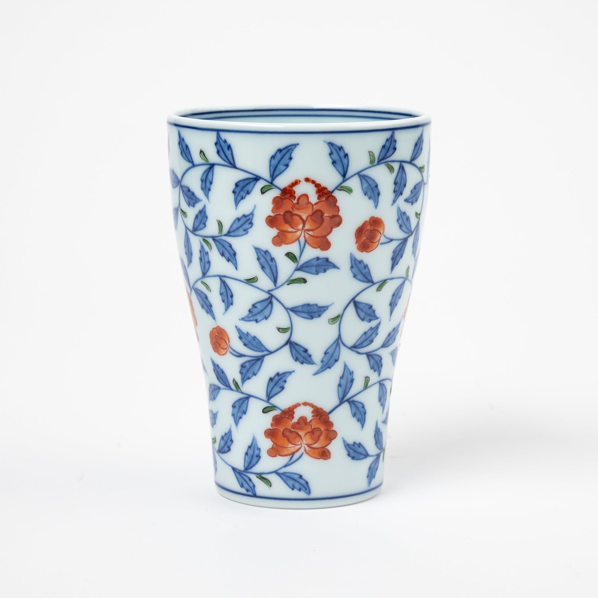 Front view of a Gen-emon porcelain cup adorned with a floral karakusa design, featuring delicate orange flowers intertwined with blue vines, representing traditional Japanese porcelain artistry.