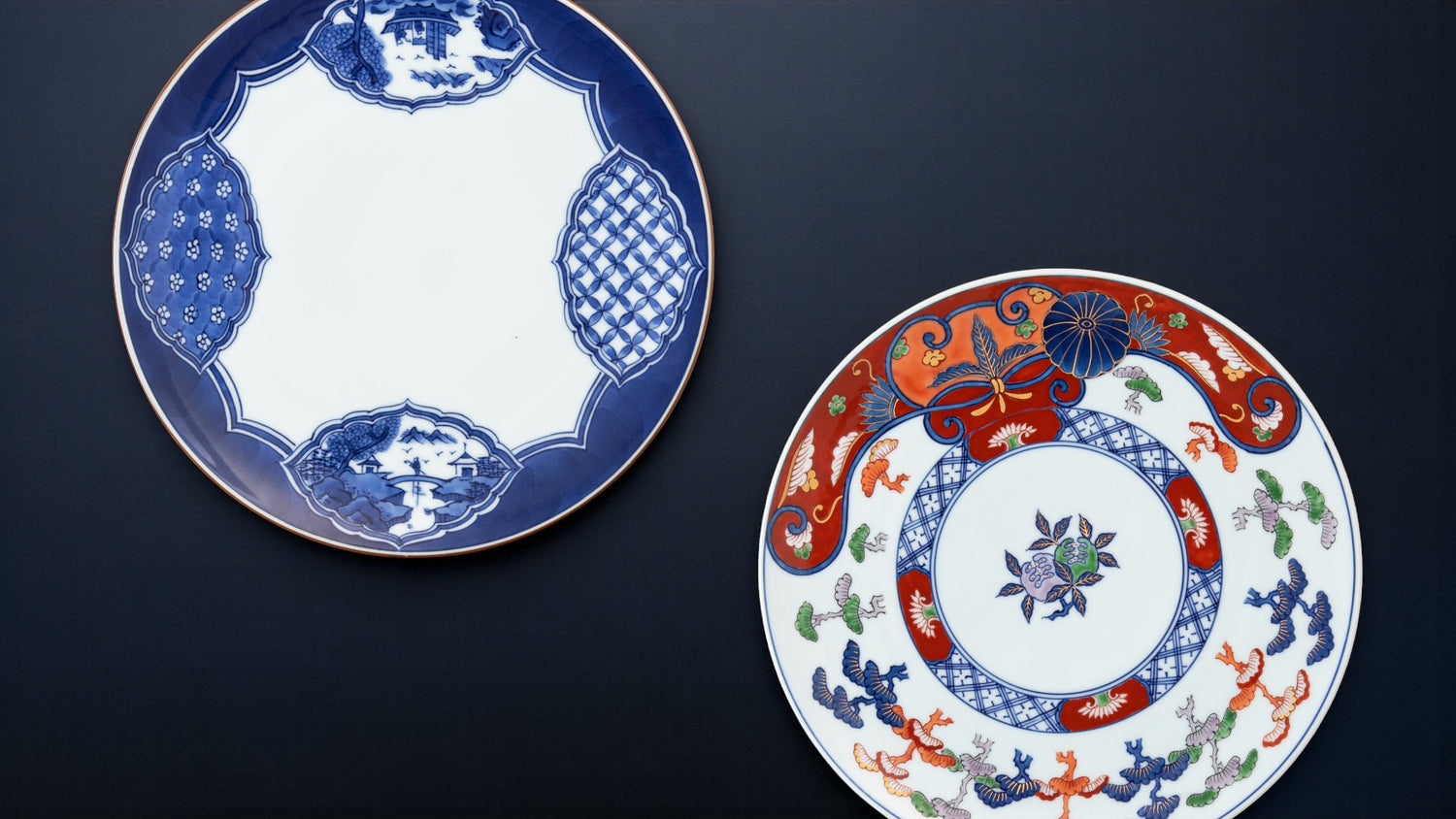 Gen-emon Kiln Arita Auspicious Medium Plate and Gen-emon Kiln Arita Edo Imari Matsue Medium Plate placed on a dark background - Omakase