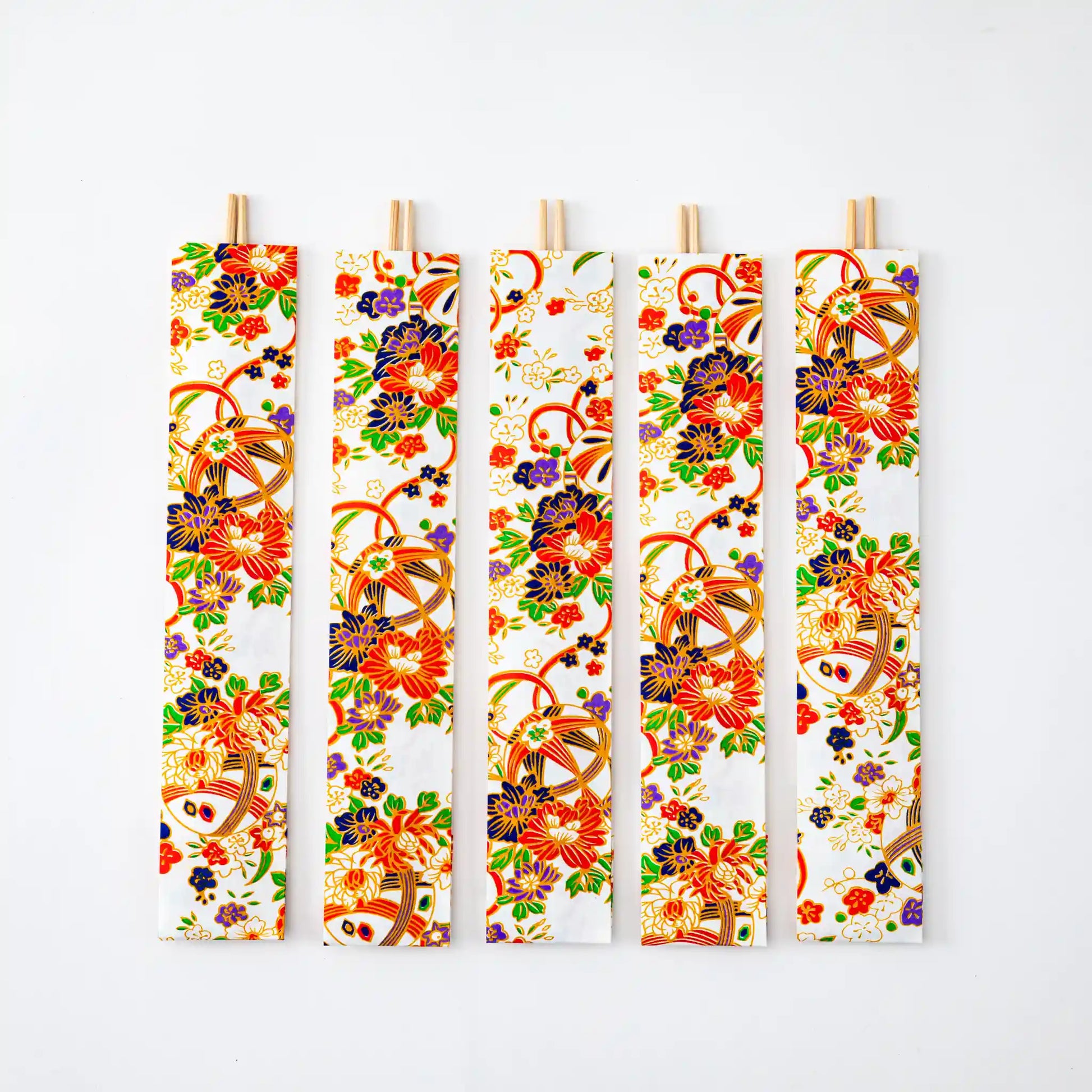 Five pairs of White Yuzen Temari Pattern Yoshino Cedar Ranchu Chopsticks, individually wrapped in ornate white paper with floral and temari motifs in vibrant red, orange, green, and purple hues, displayed in a vertical layout.