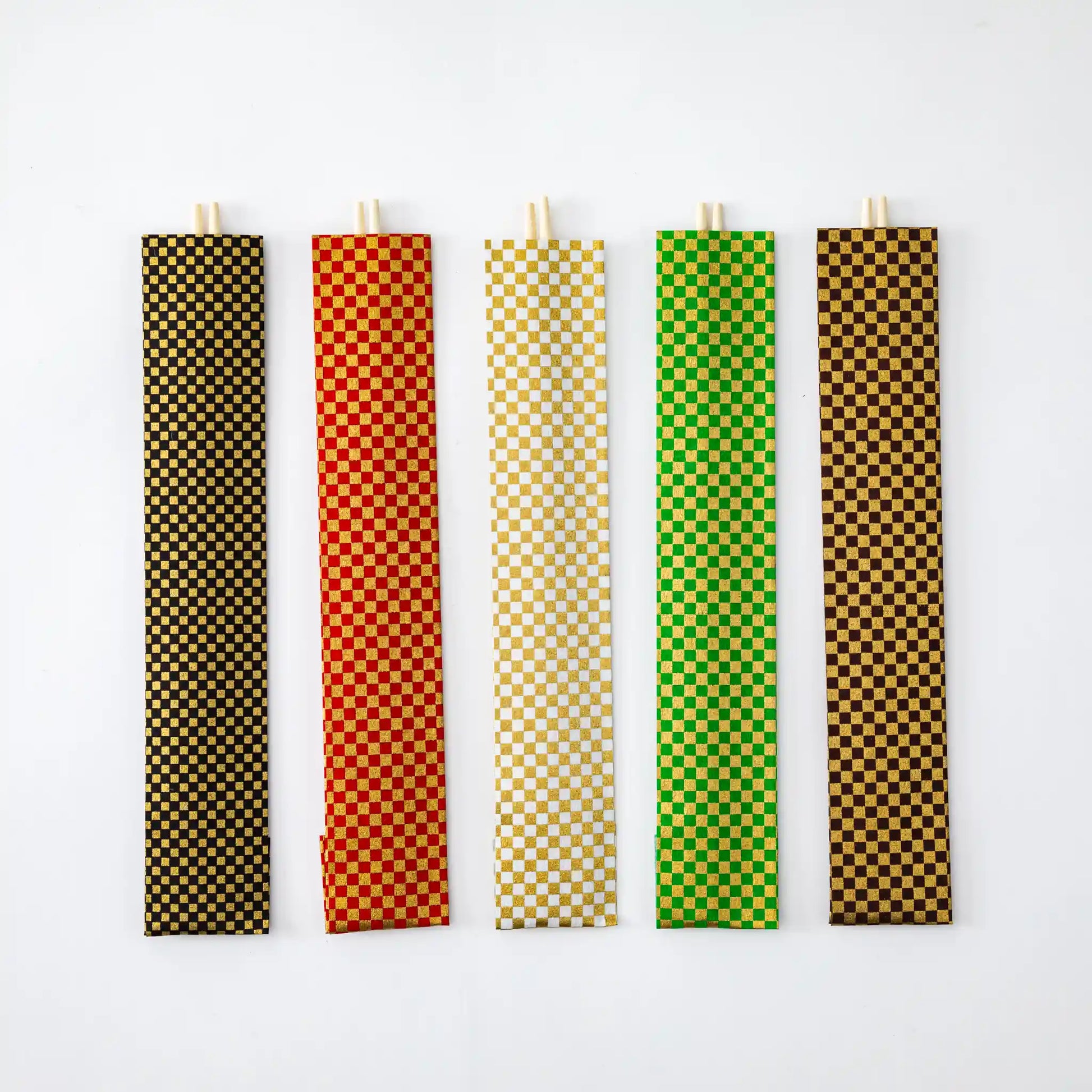 Five Kabuki Yanagi Chopsticks removed from their packaging, showcasing individual sleeves with gold and vibrant checkered patterns in black, red, white, green, and brown, against a white background.