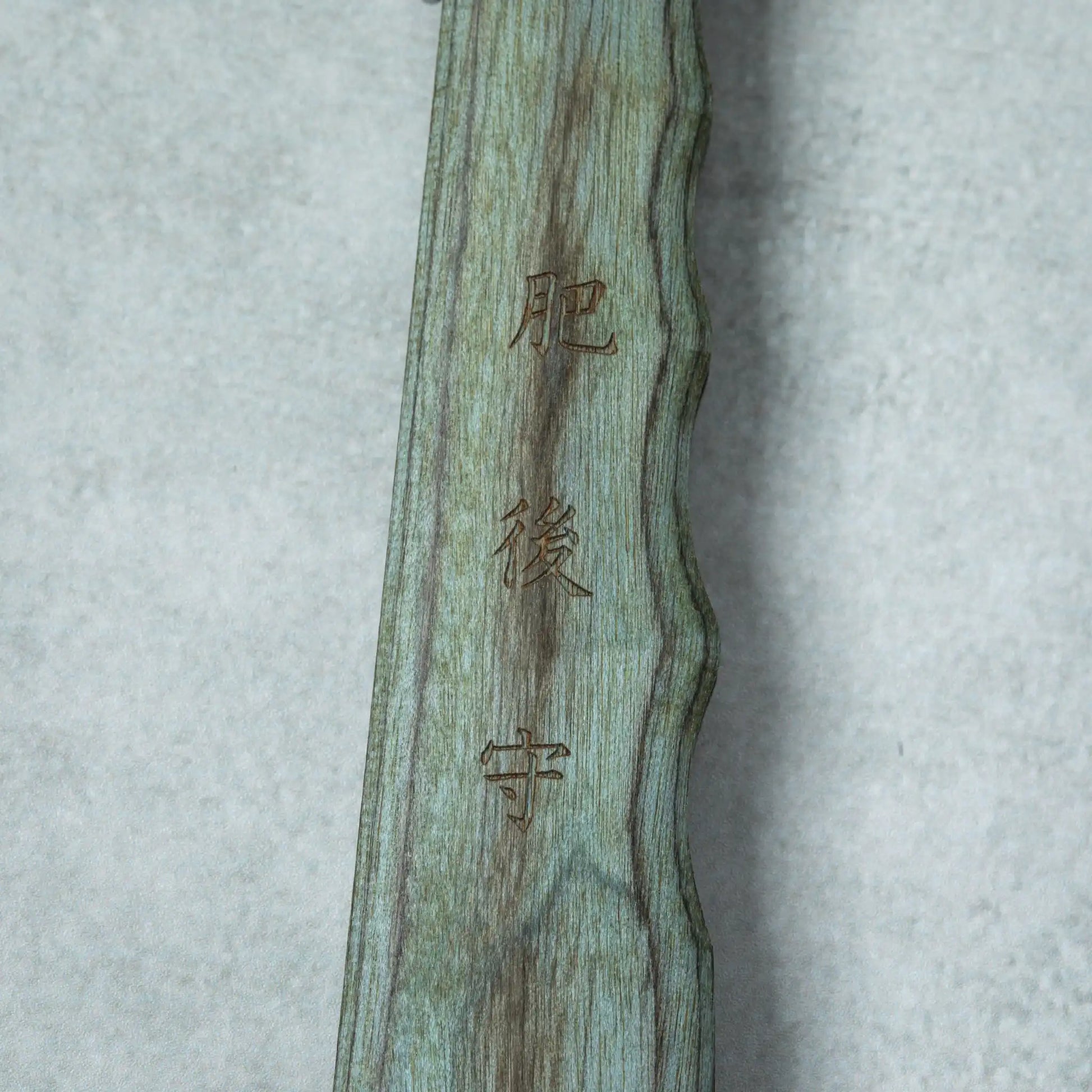 Detailed view of the Japanese characters engraved on the blue wooden handle of the Higonokami Woody VG10 knife.