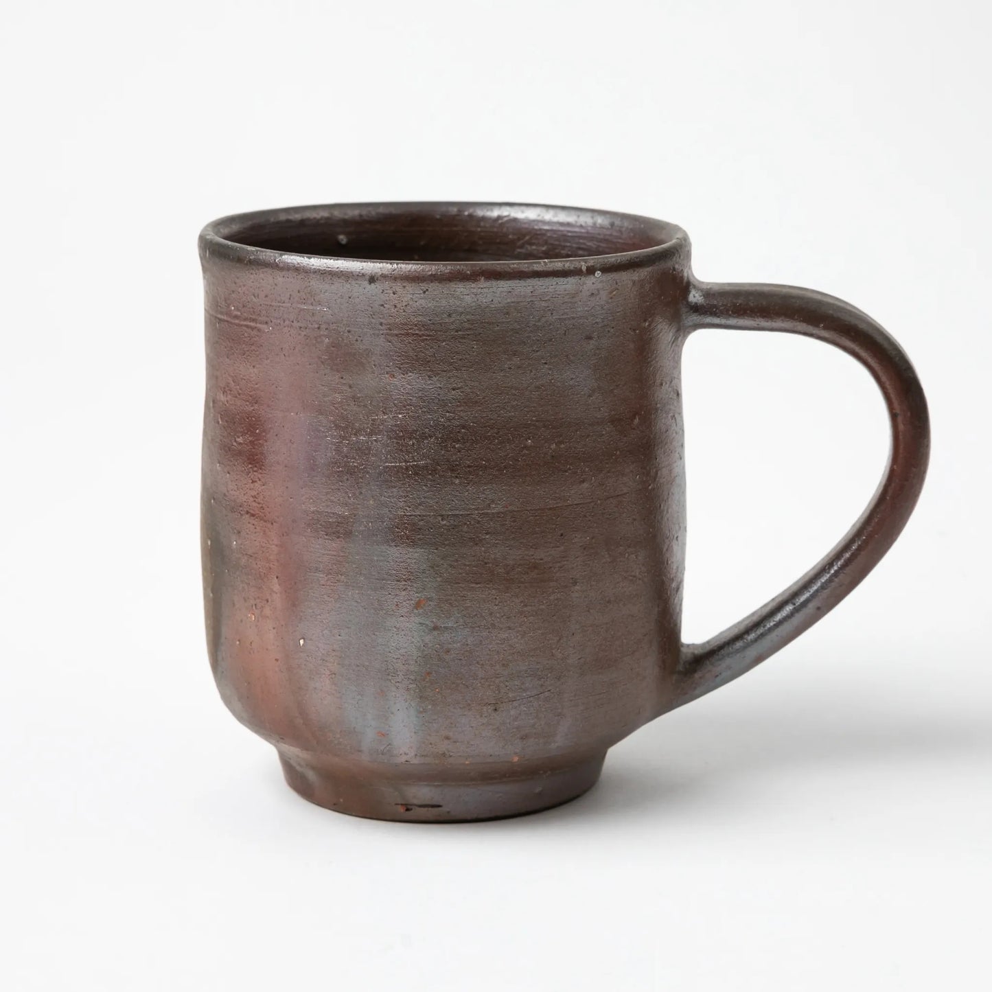 A Hozan Kiln Sangiri Large Mug in a rich dark glaze with earthy hues and a balanced handle design.