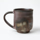 Another side view of the Hozan Kiln Sangiri Large Mug, highlighting the subtle transitions between brown, black, and smoky grey.