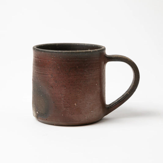 The Hozan Kiln Sangiri Mug in profile, showing a reddish-brown clay body with soft glazing transitions and an artful handle.