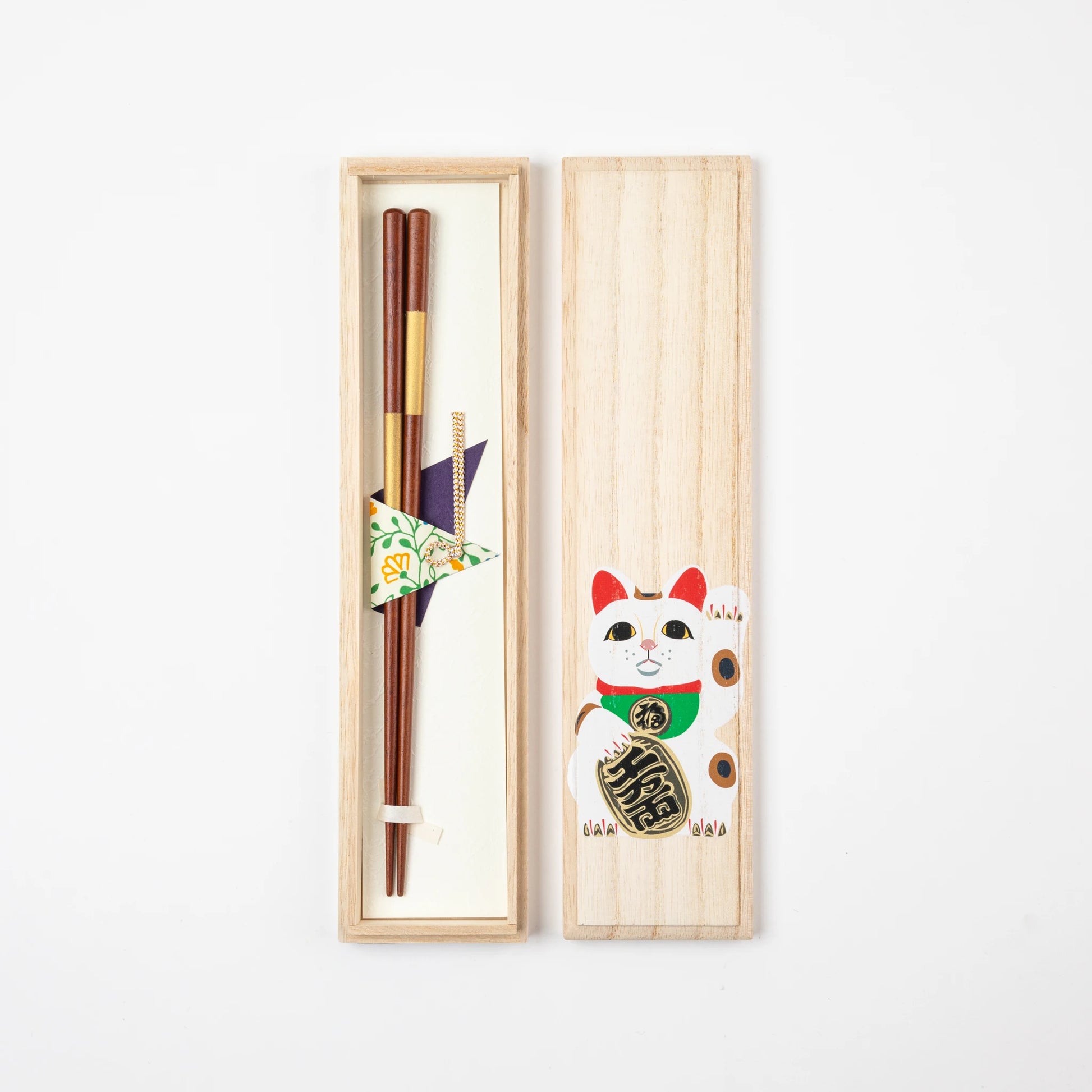 Open paulownia wood gift box featuring gold Ichimatsu lacquer chopsticks with a Maneki-neko illustration on the lid.