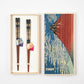 A pair of Japanese chopsticks with elegant gold and black accents in a paulownia box featuring Katsushika Hokusai's "Red Fuji."