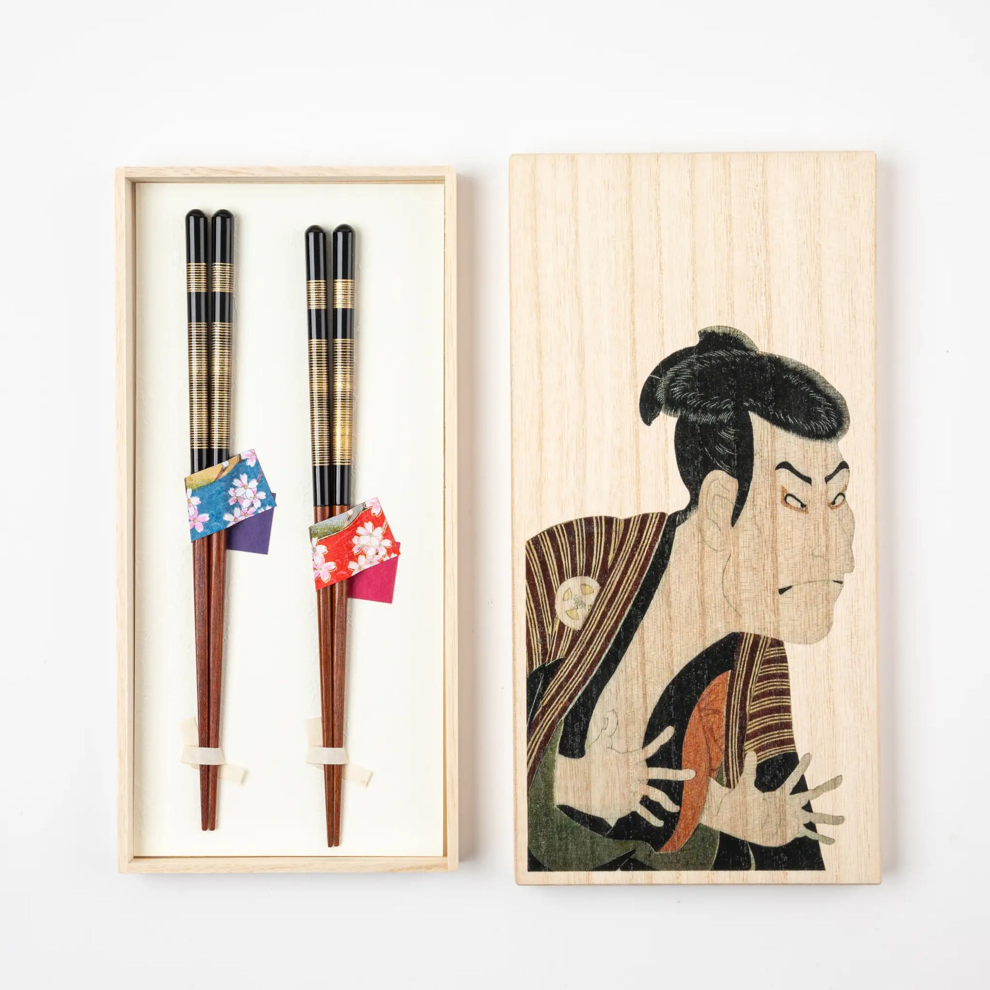 A set of two lacquered chopsticks in a paulownia wood gift box featuring a Sharaku Kabuki actor design by Hokusai