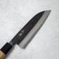 Close-up of the Ishizuchi Blue Steel No.2 Santoku Damascus Knife blade, showing the elegant Damascus wave pattern and engraved kanji.