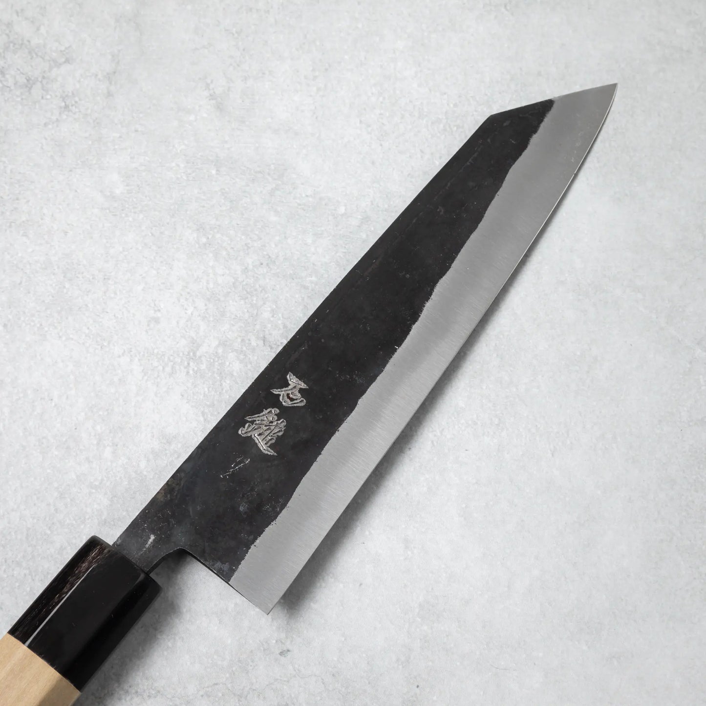 Detailed view of the blade on the Ishizuchi Blue Steel No.2 Kiritsuke Knife, featuring engraved kanji characters that add cultural authenticity.