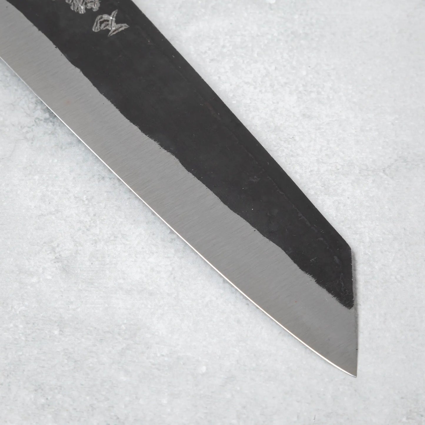 Close-up of the pointed tip and sharp edge of the Ishizuchi Blue Steel No.2 Kiritsuke Knife blade, emphasizing its craftsmanship and attention to detail.