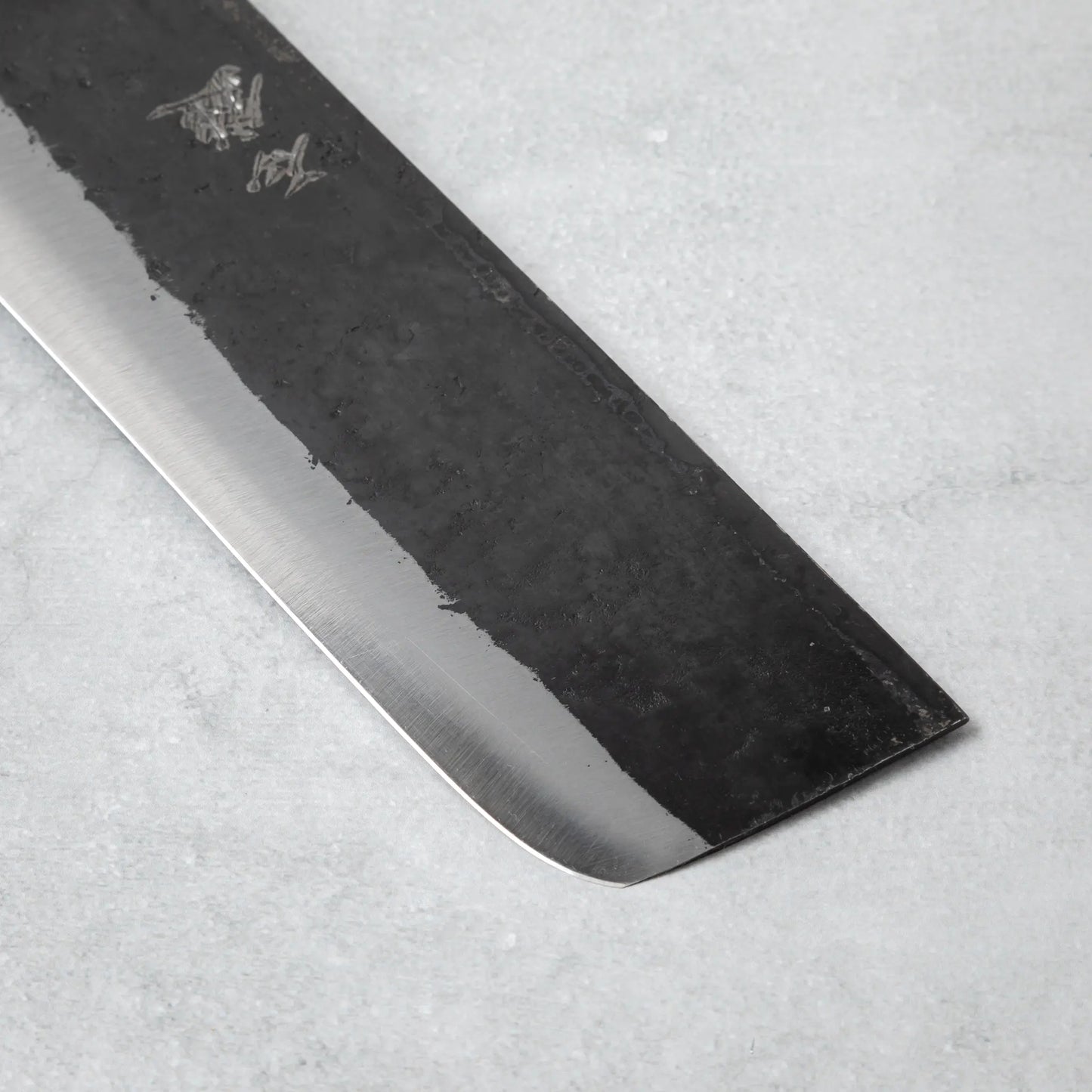 Detailed view of the edge on the Ishizuchi Blue Steel No.2 Nakiri Knife, highlighting the knife's flat blade profile for efficient chopping.