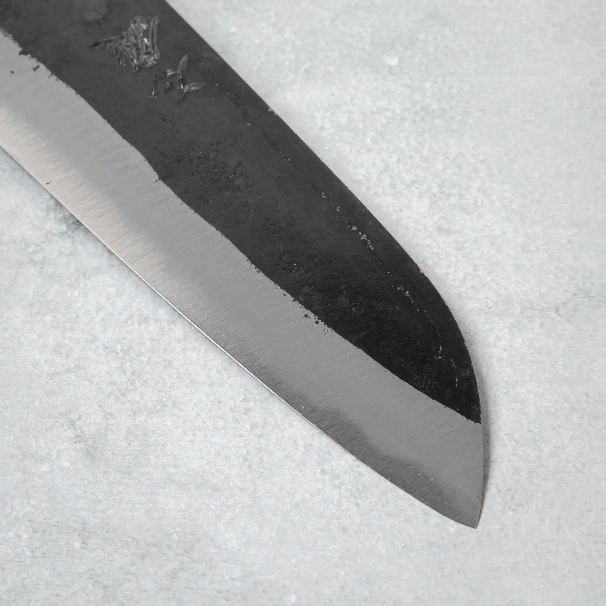 Detailed view of the tip and edge of the Ishizuchi Blue Steel No.2 Santoku Knife, emphasizing its versatility for slicing, dicing, and chopping.