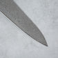 Zoomed-in view of the sharp tip of the Ishizuchi VG10 Damascus Chef Knife, highlighting the intricate Damascus steel design.
