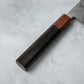 Detailed view of the Ishizuchi VG10 Damascus Kiritsuke Knife's ebony wood handle with a rosewood accent, highlighting its smooth and refined craftsmanship.