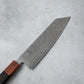Close-up of the Damascus steel blade on the Ishizuchi VG10 Kiritsuke Knife, featuring intricate wave-like patterns and engraved kanji characters.