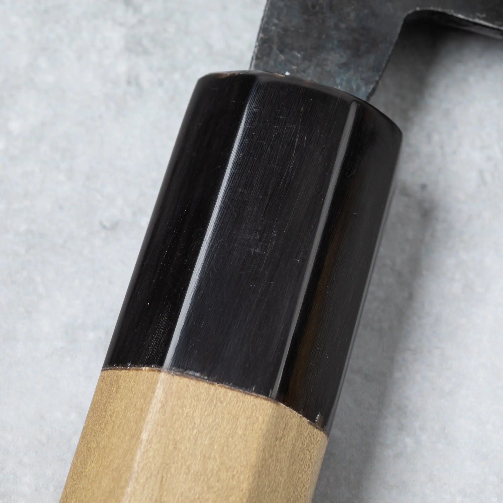 Detailed view of the buffalo horn ferrule on the Ishizuchi Blue Steel No.2 Chef Knife handle, emphasizing its sleek, polished finish.