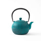 Side view of the Japanese Aster sky blue Nanbu cast iron teapot, highlighting the spout and intricate ribbed pattern.