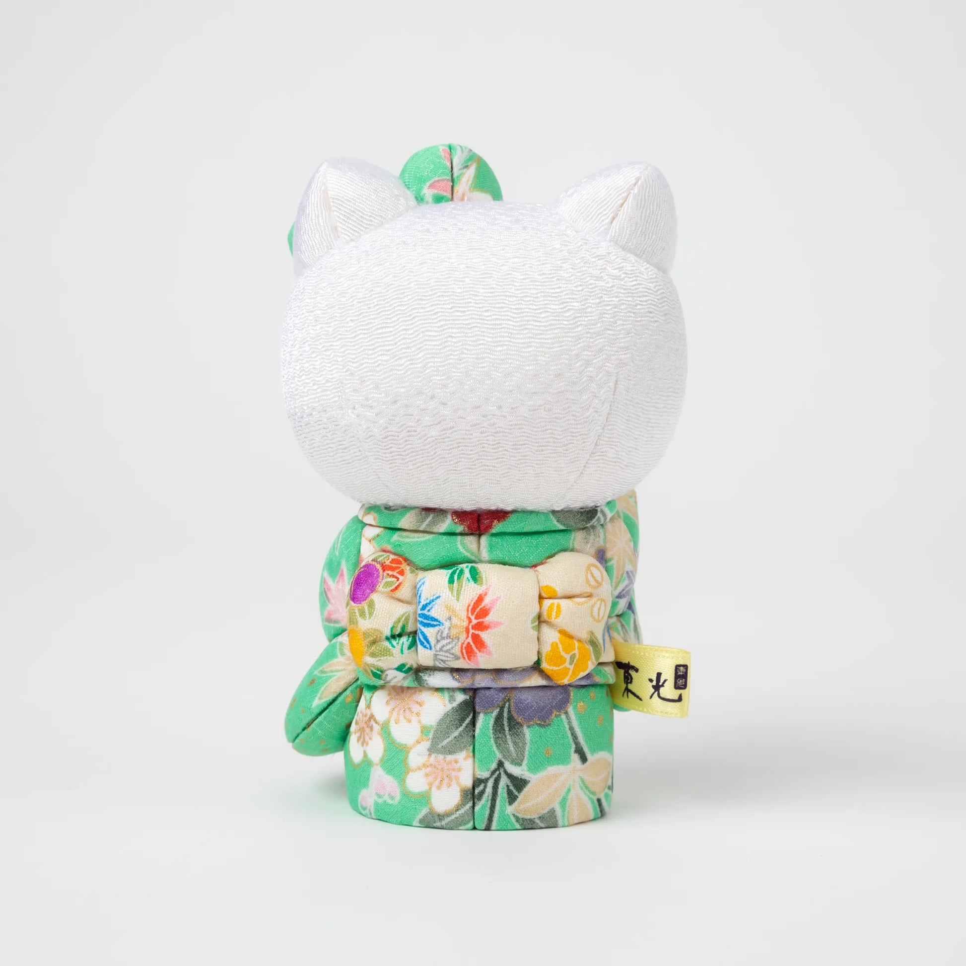 Back view of the Edo Kimekomi Kimono Maneki Hello Kitty Green, revealing the detailed bow and floral patterns on the green kimono, symbolizing the Edo Kimekomi doll craftsmanship.