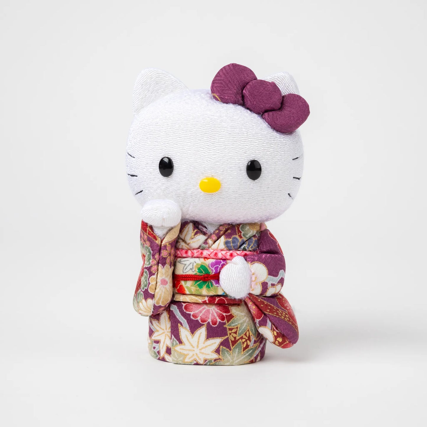 Front view of the Edo Kimekomi Kimono Maneki Hello Kitty Purple, featuring Hello Kitty in a traditional Japanese kimono with a purple floral pattern and a decorative bow on her head.