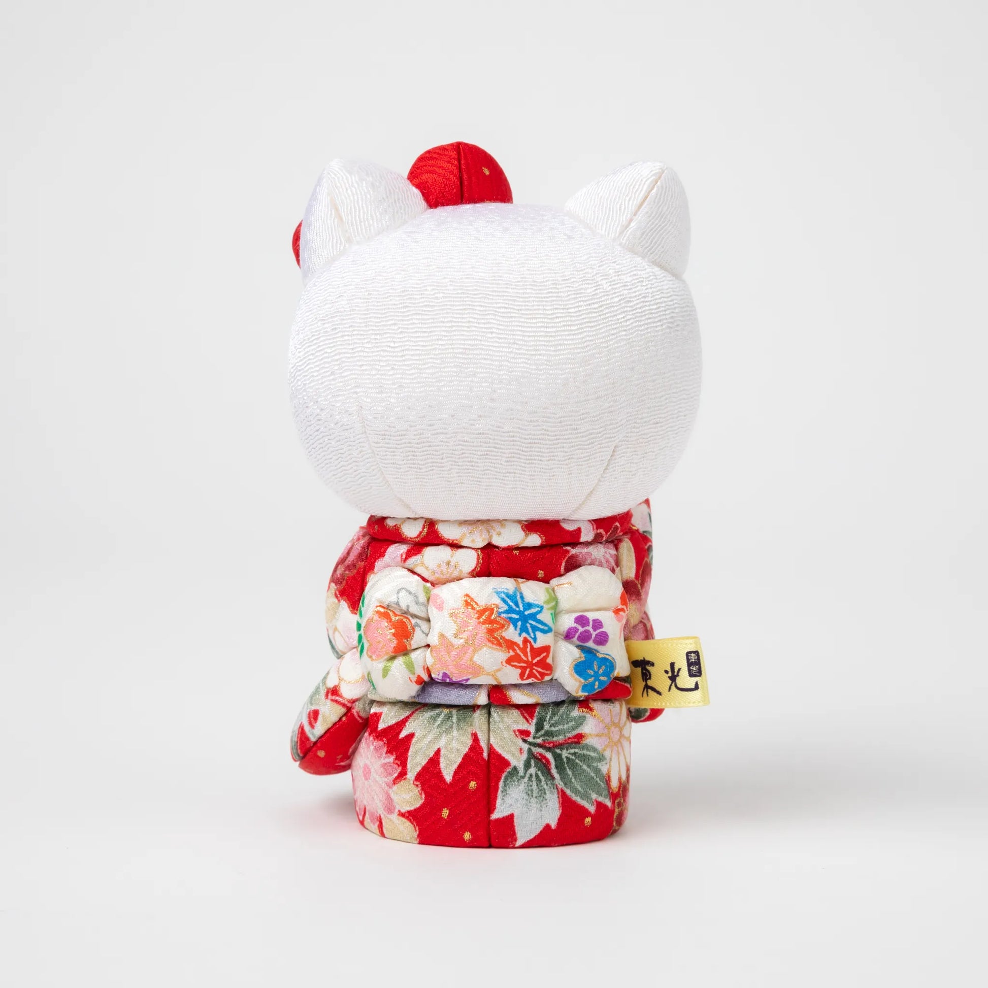 Back view of the Edo Kimekomi Kimono Maneki Hello Kitty Red, revealing the detailed bow and floral patterns on the red kimono, symbolizing the Edo Kimekomi doll craftsmanship.