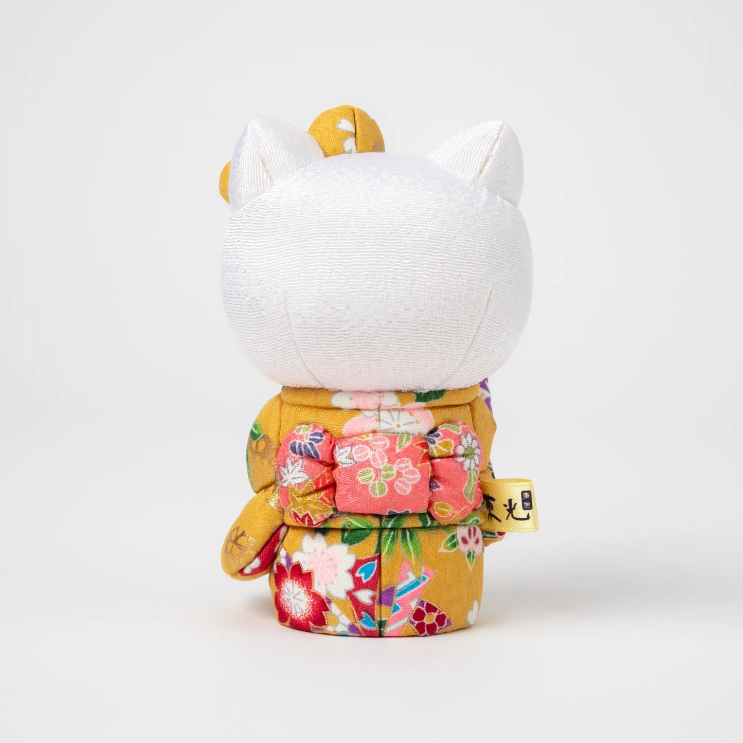 Back view of the Edo Kimekomi Kimono Maneki Hello Kitty Yellow, revealing the detailed bow and floral patterns on the yellow kimono, symbolizing the Edo Kimekomi doll craftsmanship.