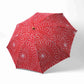 Isa Moyō Folding Umbrella fully opened, showcasing the bold Chrysanthemum motif against a red background.