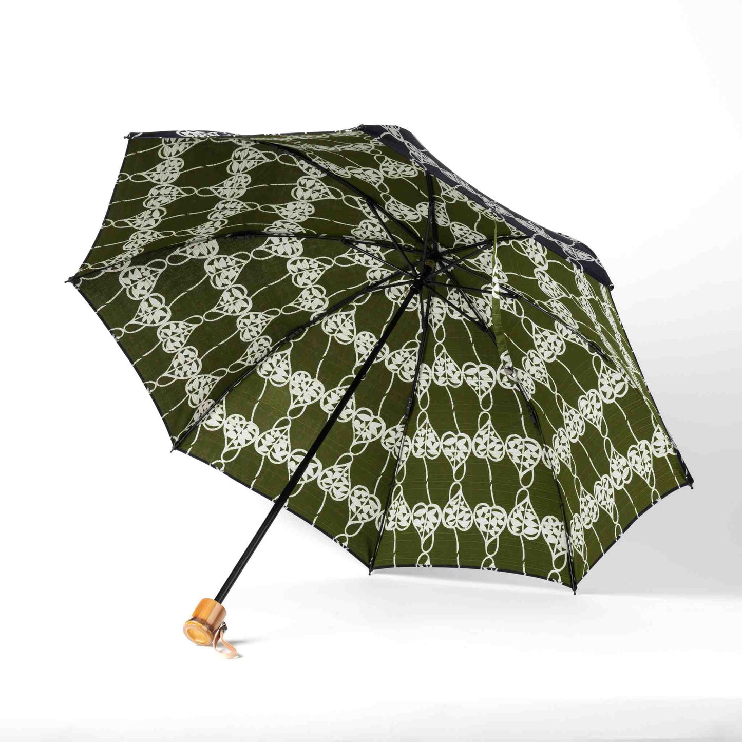 Isa Moyō Folding Umbrella opened, revealing the Rosary Vine motif on a green background, with the bamboo handle visible.