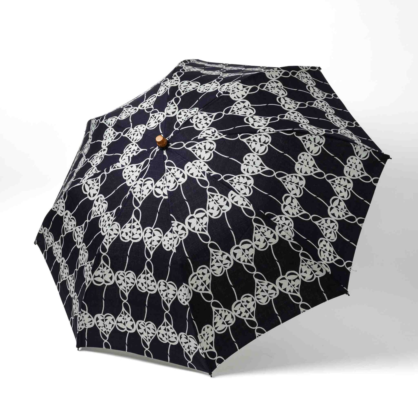 Isa Moyō Folding Umbrella fully opened, showcasing the intricate Rosary Vine motif against a deep navy background.