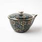 Kutani Aochibu Tessen teapot with a dark blue base, adorned with delicate gold floral motifs and a turquoise dotted design, complete with a fitted lid.