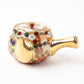 Close-up of the teapot from the Kutani Blooming Flowers tea set, decorated with multicolored chrysanthemum designs and gold accents, featuring a golden spout and handle.