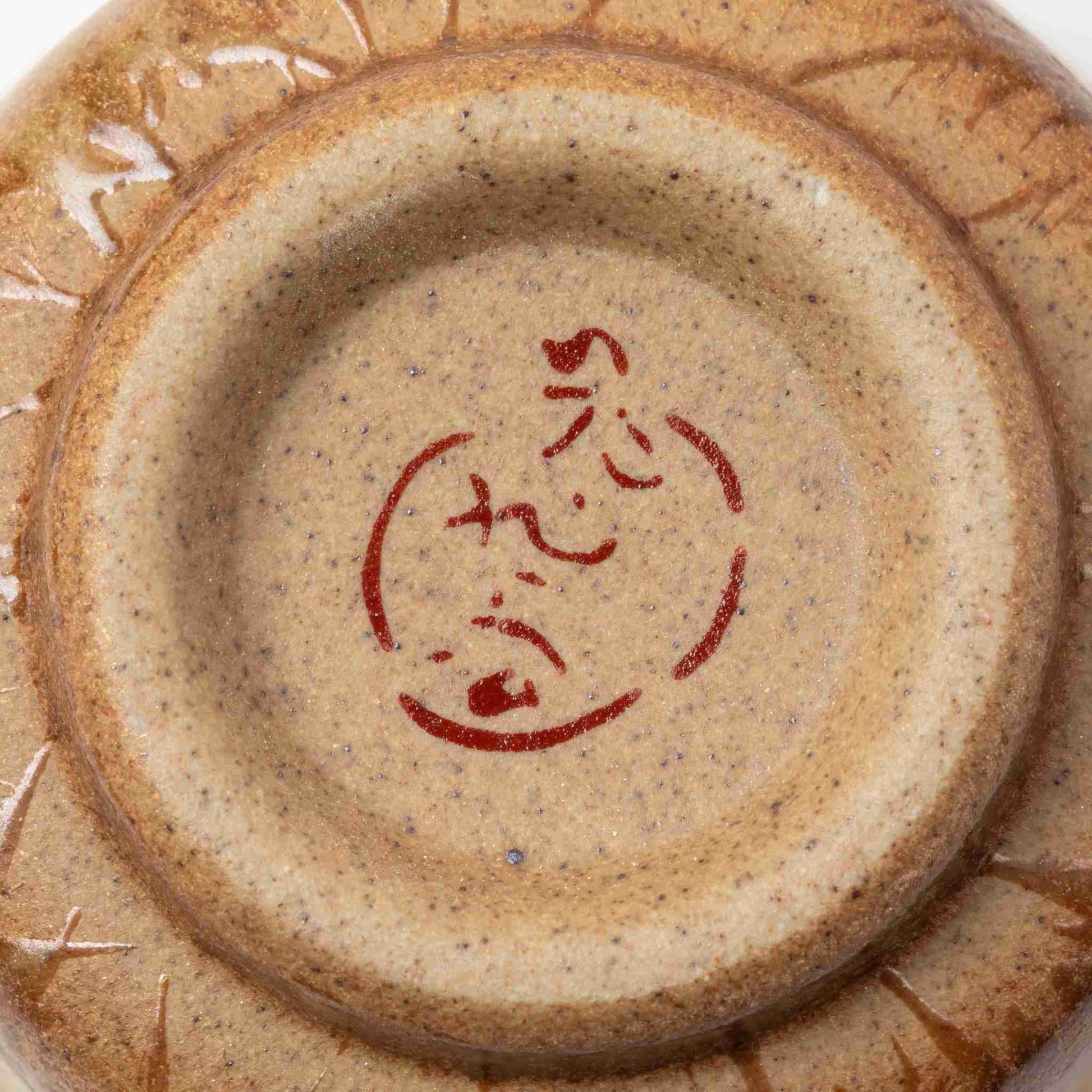 Underside view of a Kutani gold leaf sake cup, showing the artisan’s signature mark for authenticity.