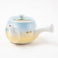 Side view of the Kutani Mountain Range teapot with gold leaf detailing and smooth porcelain handle