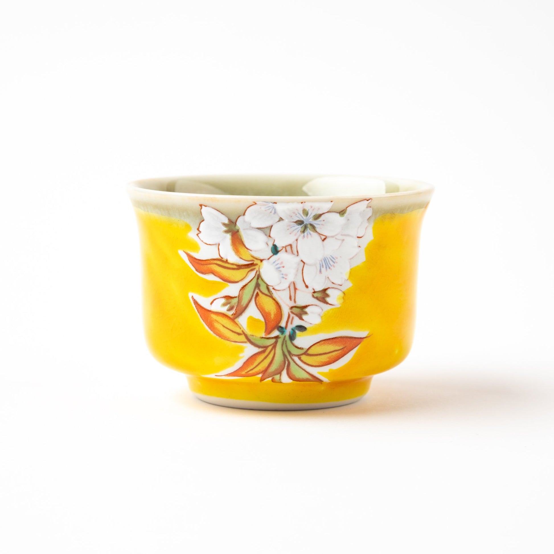 Another view of the yellow sake cup, displaying its hand-painted cherry blossom design and decorative elements.