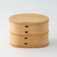 A small two-tiered wooden bento box with the lid on, highlighting its minimalist design.