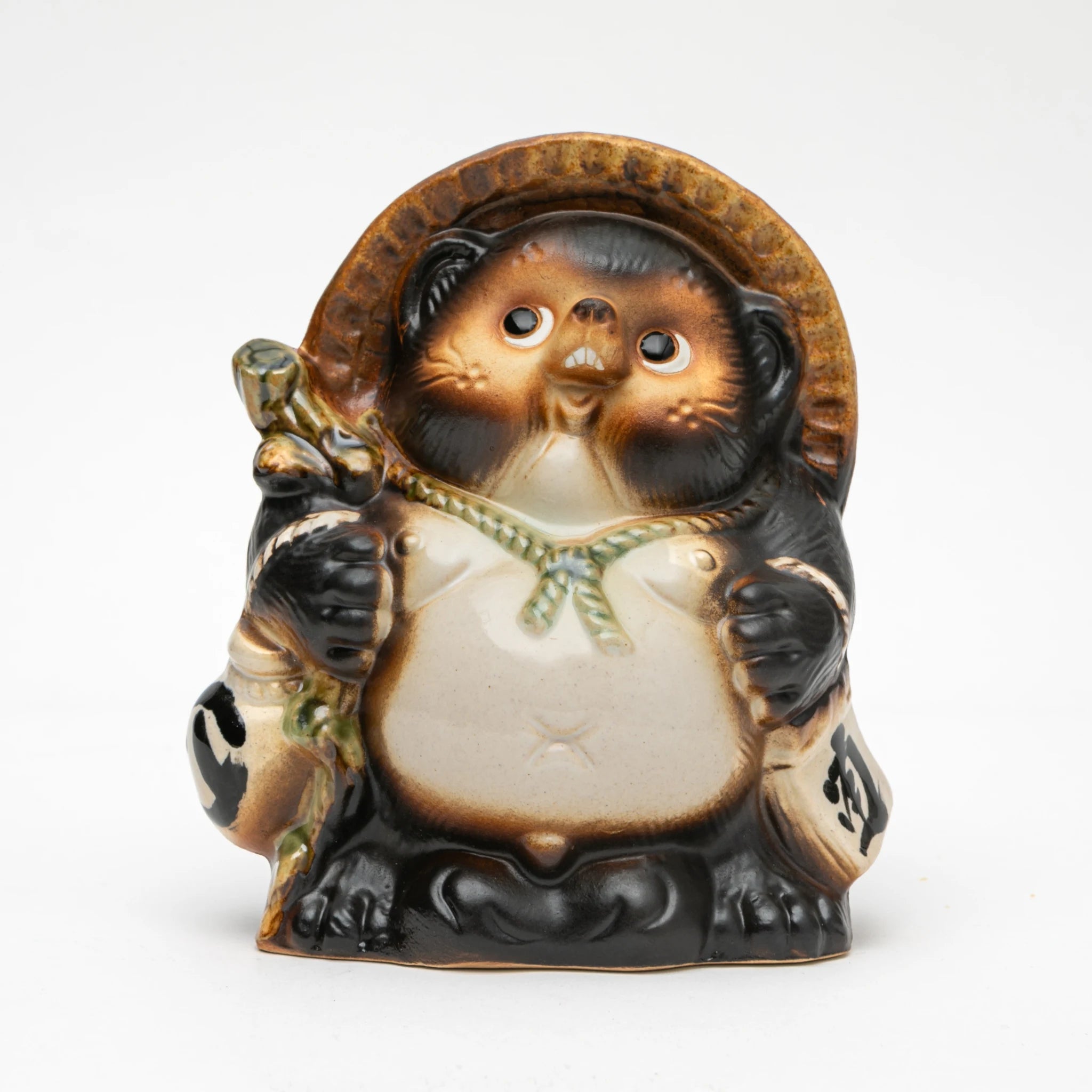 Front view of the Maruichi Shigaraki ware Fukufuku tanuki figurine male, showing a round standing form with straw hat, pale robe tied at center, sake flask, and wide-eyed expressive face with bared teeth.