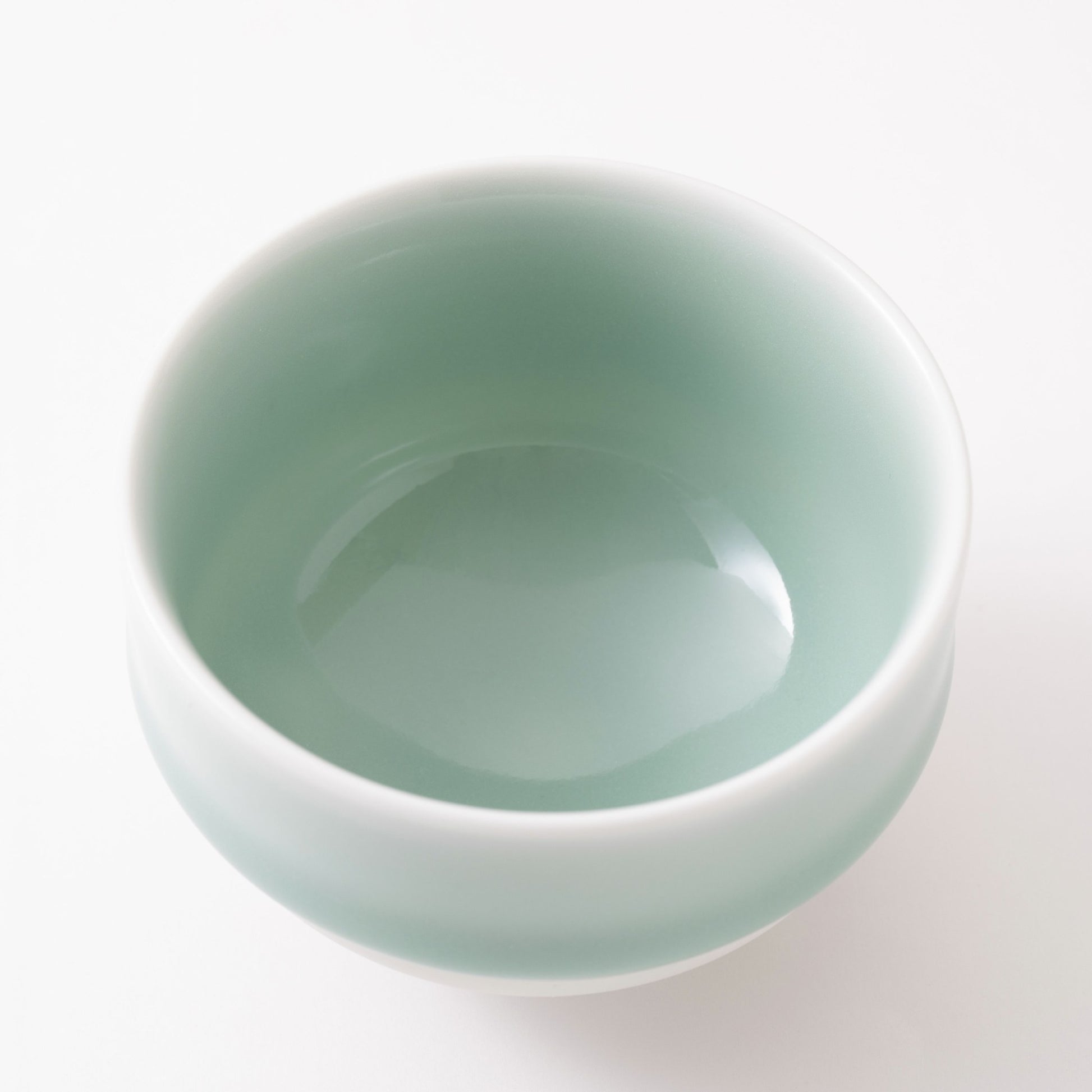 Top view of a Nabeshima Celadon porcelain tea cup showcasing its smooth, glossy green interior.