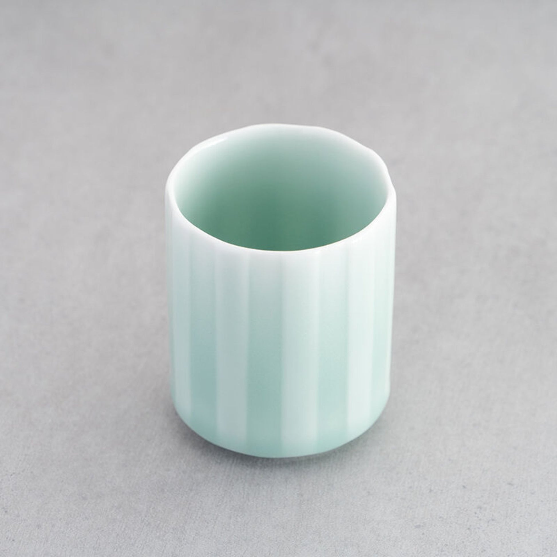 Elegant Nabeshima Celadon Porcelain Teacup with a soft green glaze, displayed on a gray background.