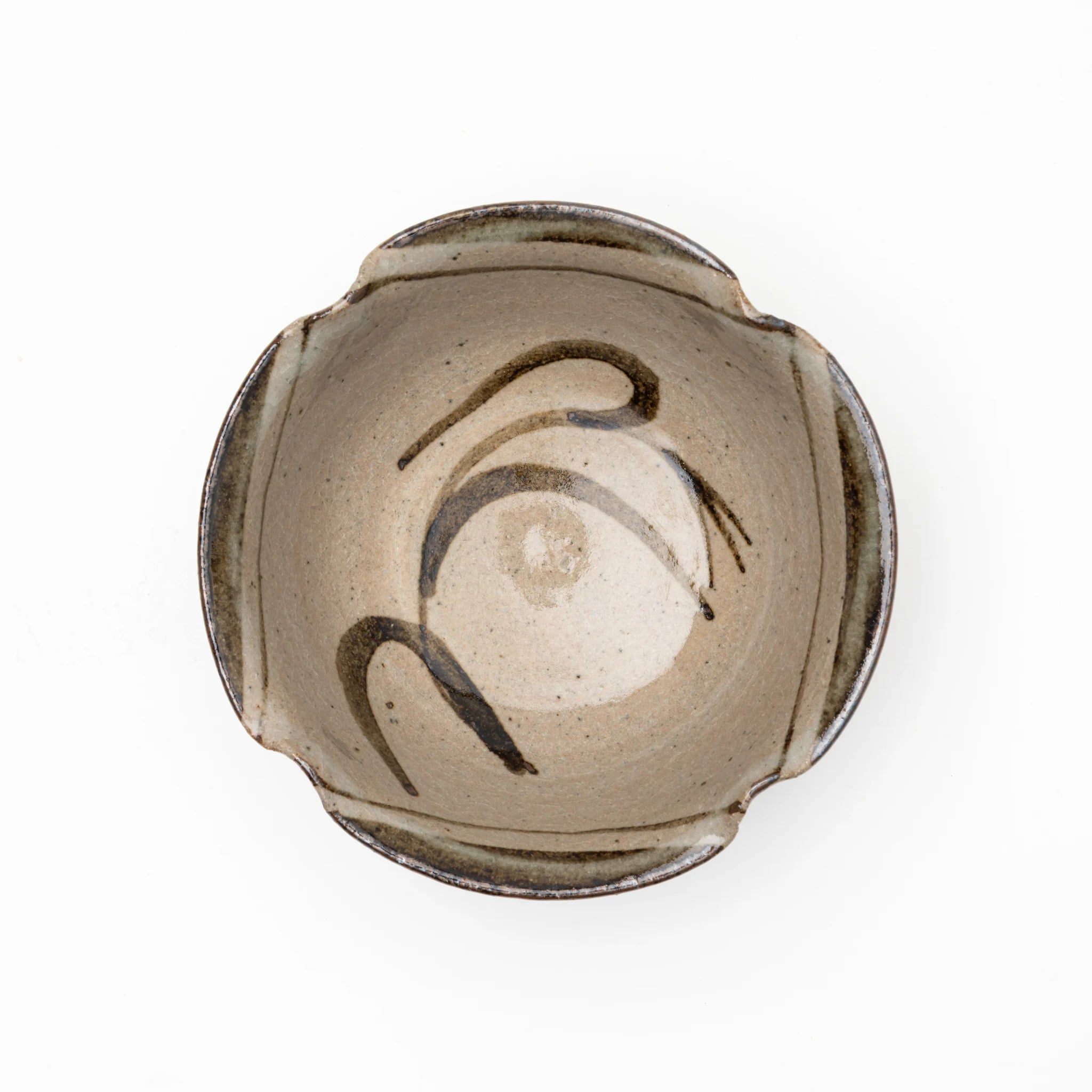 Top view of the Nakazato Tarouemon E-Karatsu susuki mukozuke serving dish, showing a rounded form with a 4-point lobed rim, pale coarse stoneware ground, and sweeping iron-oxide brushwork of pampas grass stems across the interior.