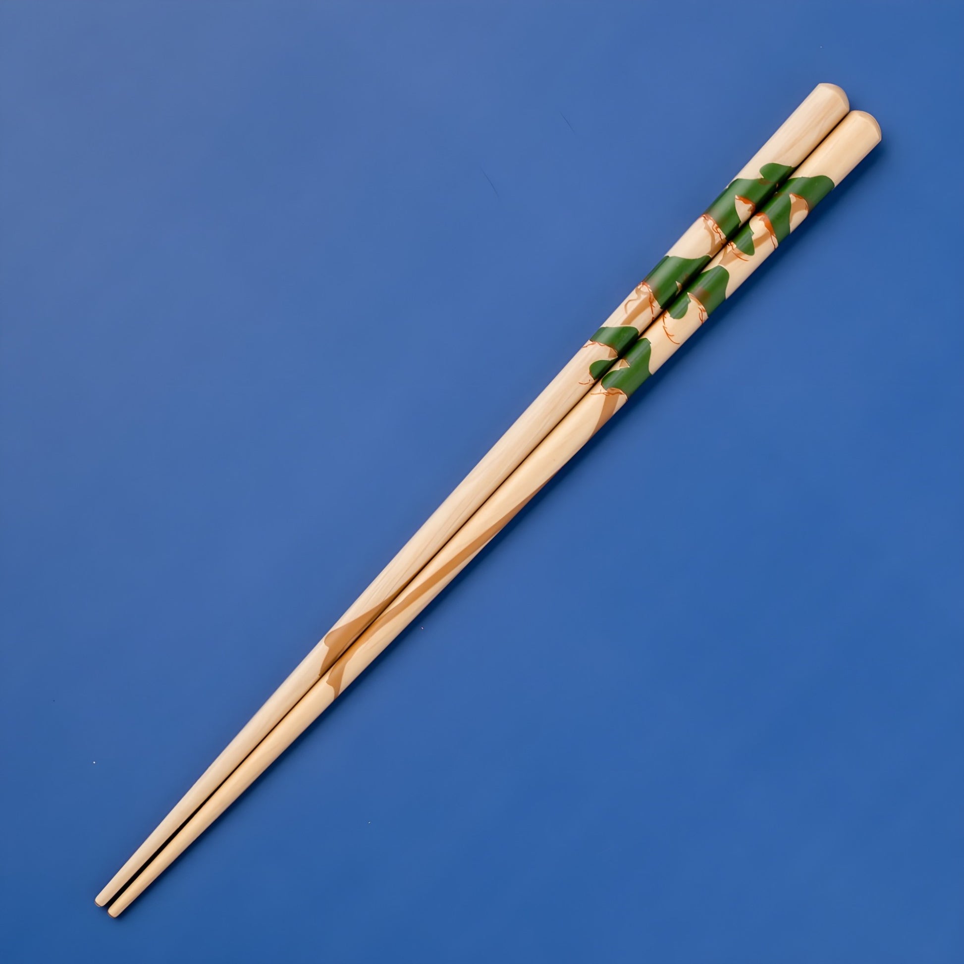 Natural wood chopsticks adorned with a pine tree design, showcasing leaves intertwined with golden accents.