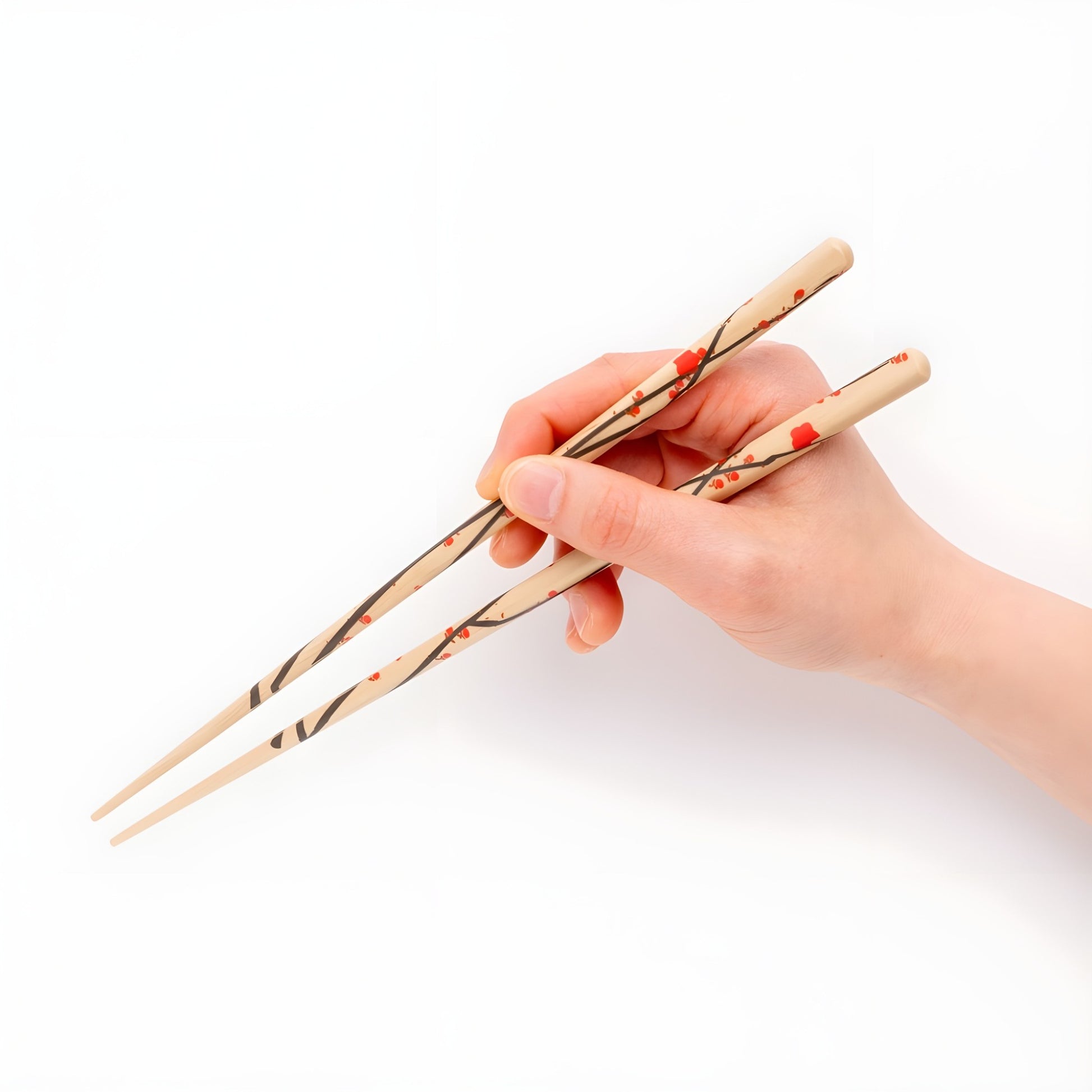 A hand holding natural wood chopsticks featuring a red plum blossom design with black branches and red flowers, crafted for elegance and style.