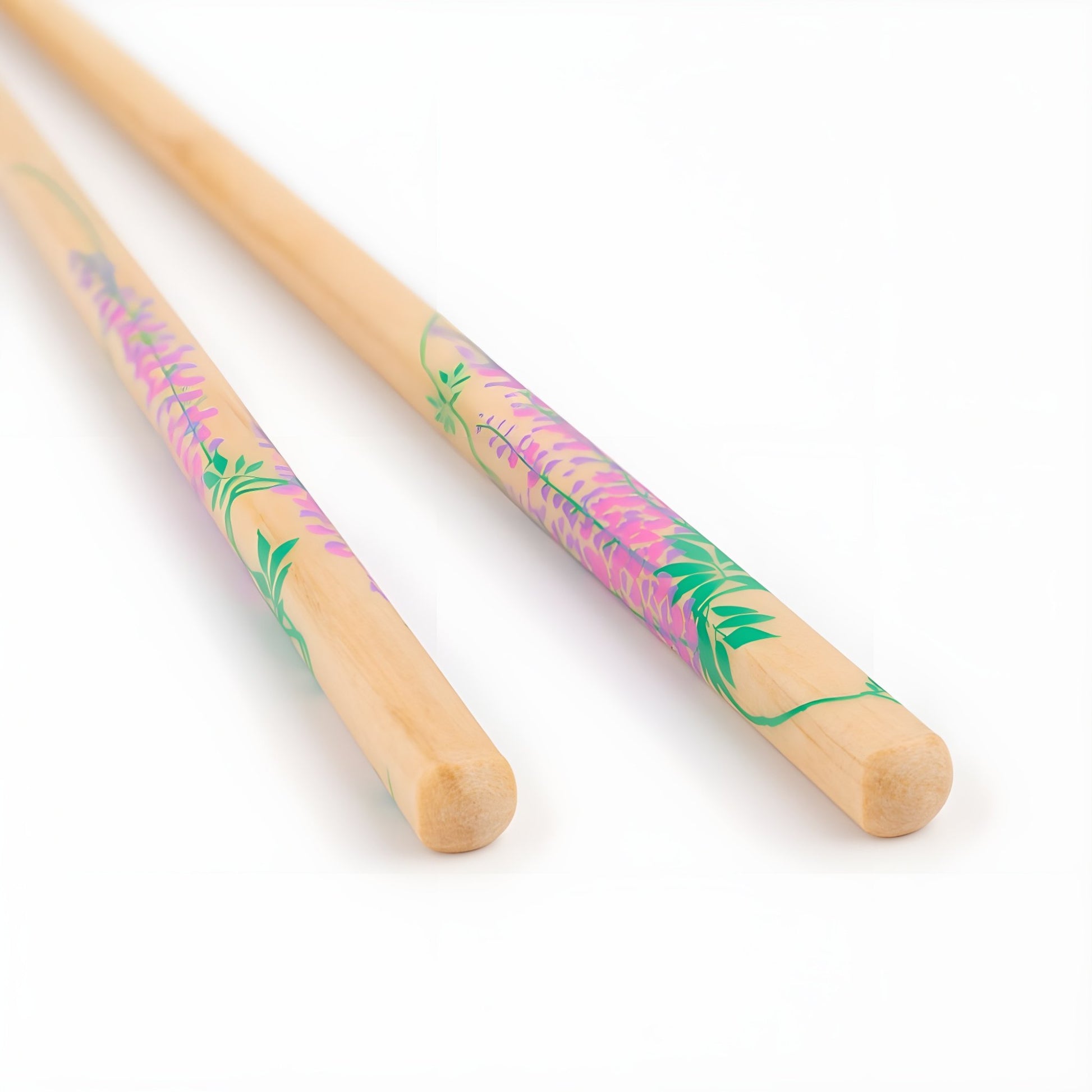 Close-up of natural wood chopsticks with vibrant purple wisteria flower designs, painted delicately against a light wood base.