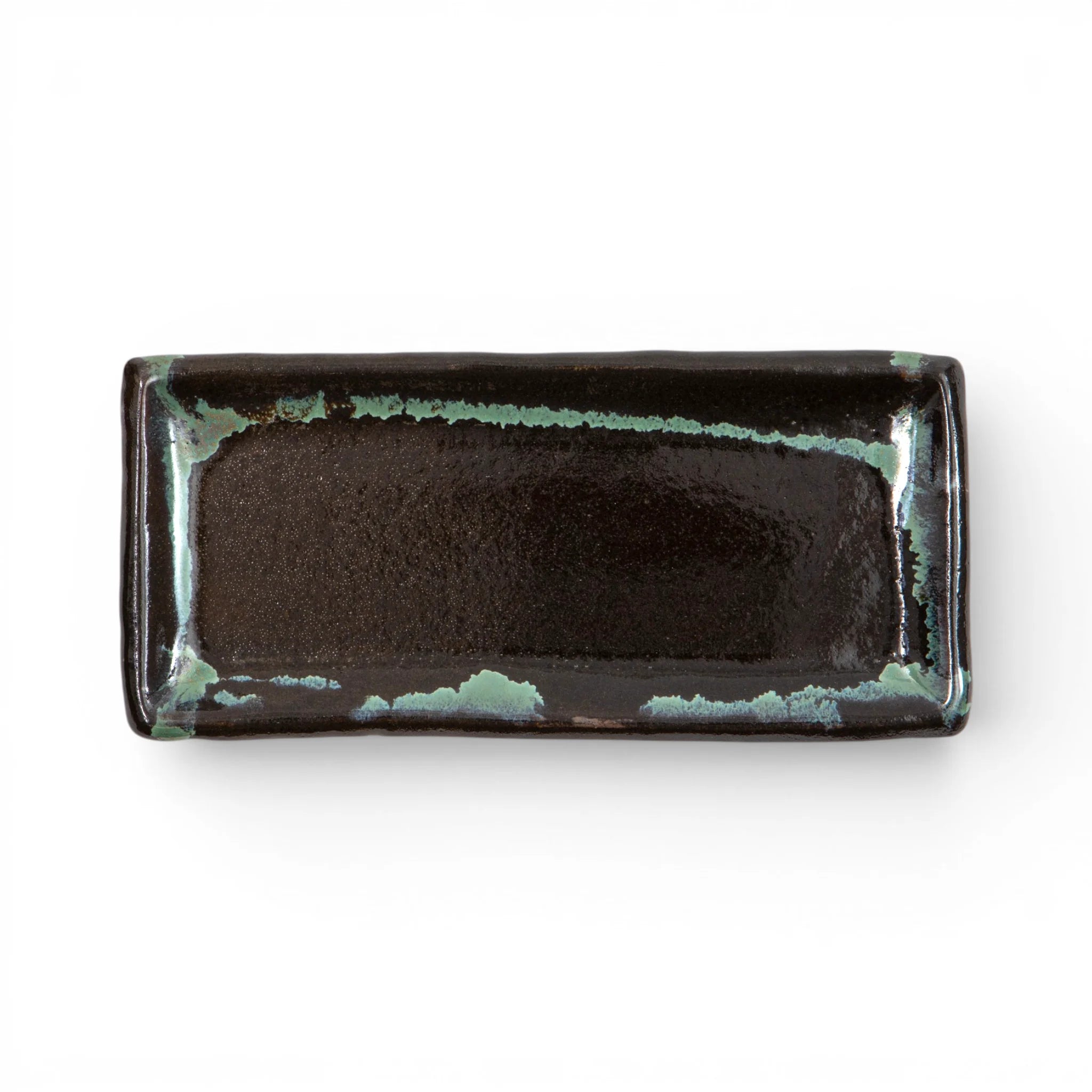 Top view of a Ryumonji Yaki rectangular pottery plate showing a deep black kuro glaze field with teal accumulation along the rim and corners.
