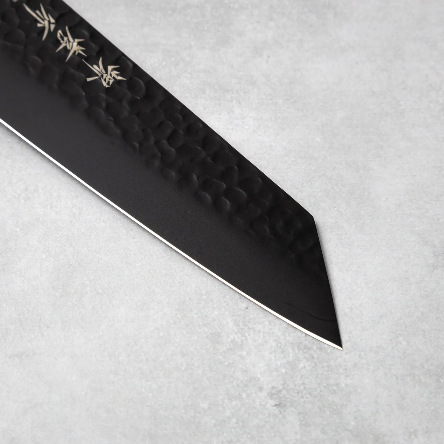 The precise blade tip of the Sakai Takayuki Kurokage VG10 petty knife, emphasizing its sharp edge and detailed craftsmanship.