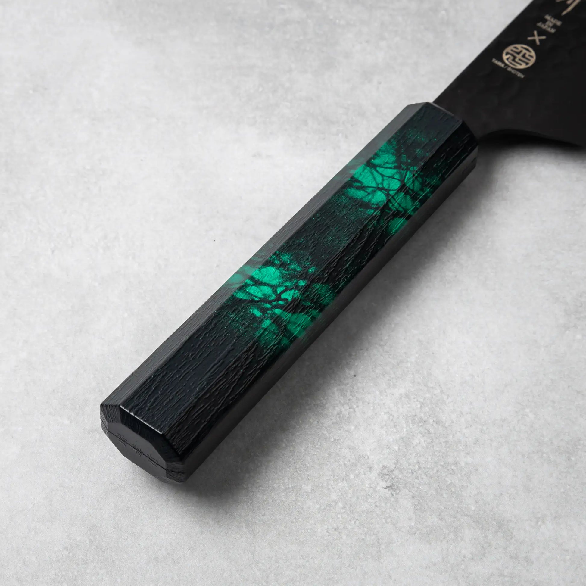 Detailed view of the Sakai Takayuki Kurokage VG10 Kengata Santoku Knife’s green handle with marbled patterns and octagonal design.