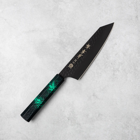 Full view of the Sakai Takayuki Kurokage VG10 Kengata Santoku Knife featuring a hammered black blade and green handle on a gray surface.