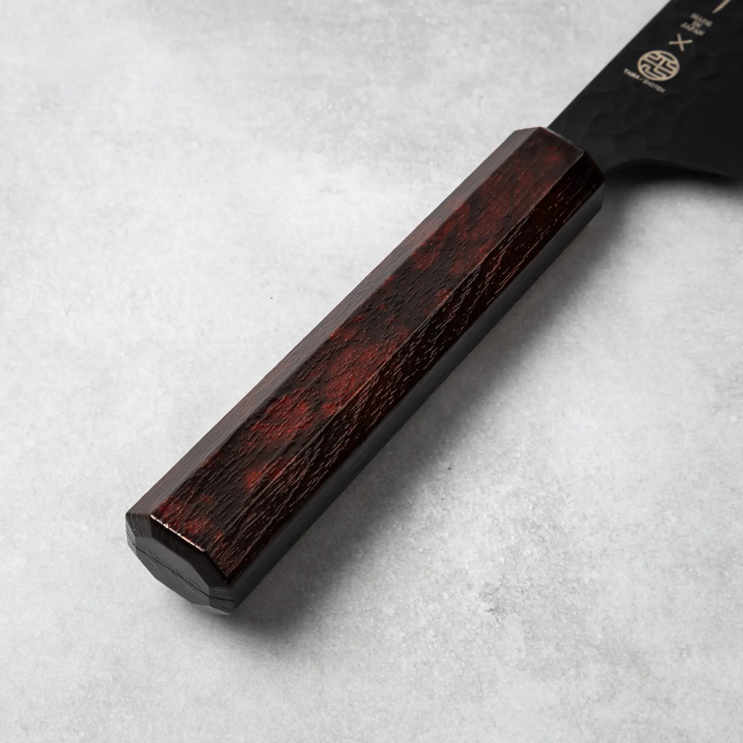 Focused view of the burgundy handle of the Sakai Takayuki Kurokage VG10 Kengata Santoku Knife displaying its smooth finish and octagonal shape.