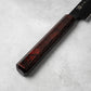 A detailed view of the burgundy resin handle of the Sakai Takayuki Kurokage VG10 petty knife, highlighting its smooth finish and subtle marbled design.